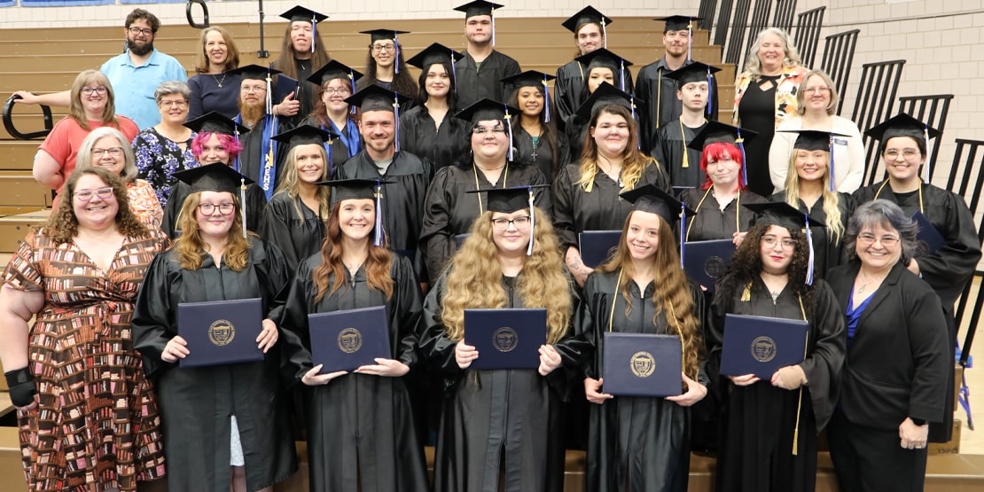 High school equivalency students posing with their diplomas