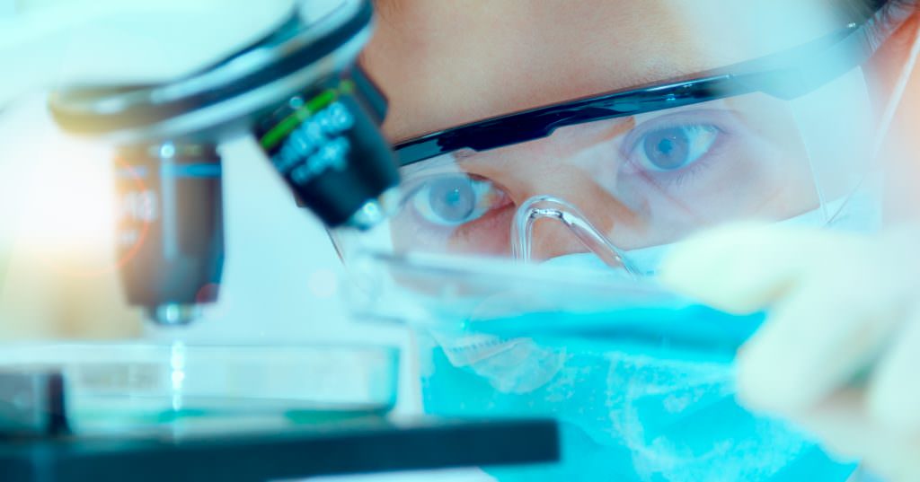 Lab technician using microscope