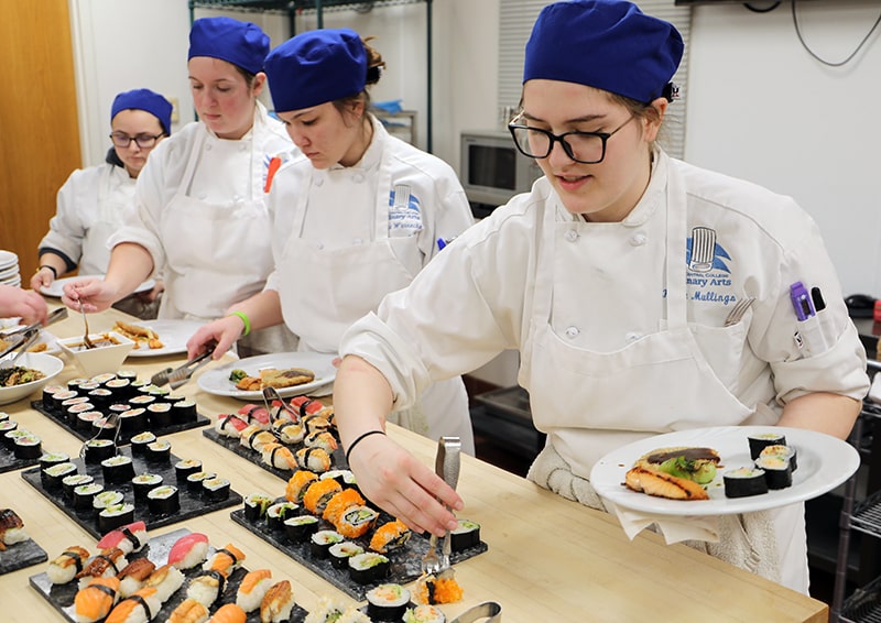 Culinary arts students preparing sushi