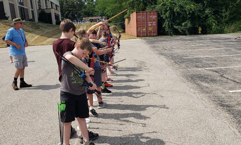 Young students lined up in parking lot with bows