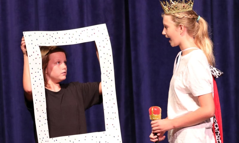 Young students acting in play on stage