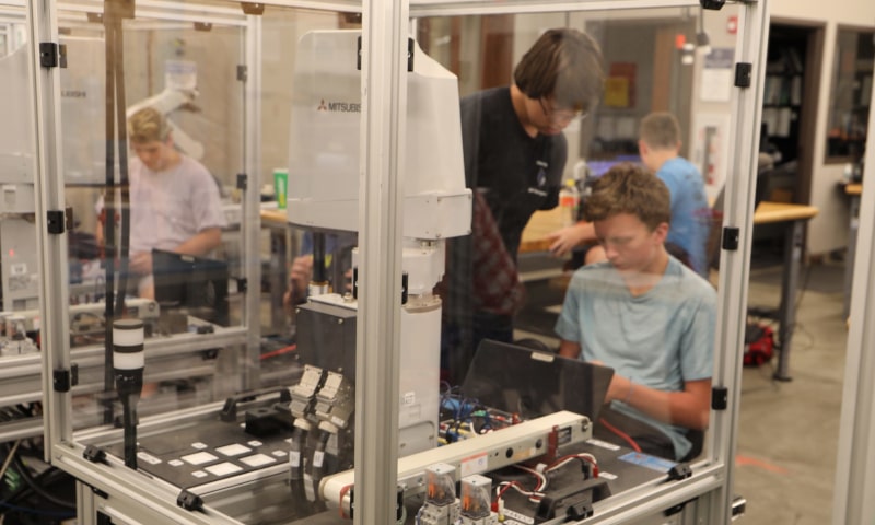Students working with industrial engineering equipment