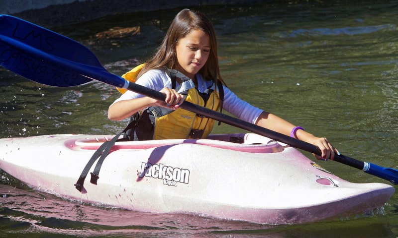 Young girl paddling on a kayak