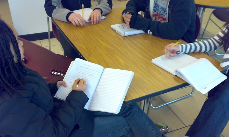Students sitting around a table with notebooks