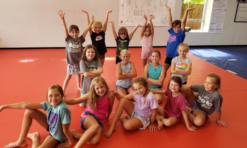 Group of young students posing for photo on gym mat