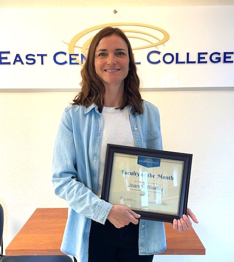 Joannie Blakely smiling with her Faculty of the Month certificate.
