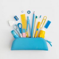 Pencil case with school stationery on a grey background