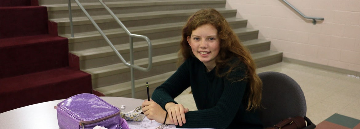 Student smiling at camera in the lobby