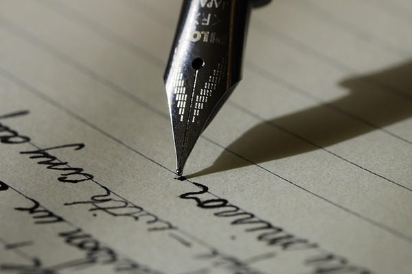 Tip of pen writing on ruled paper