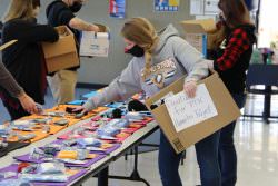 Student packing box of donated items