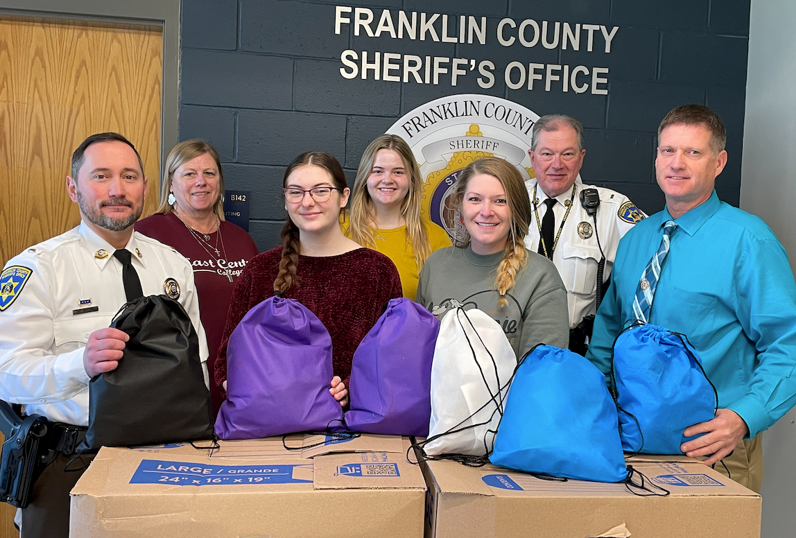 Sheriffs office members and students with donation bags for unhoused people