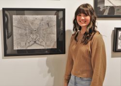 Parker Williamson posing next to her illustration