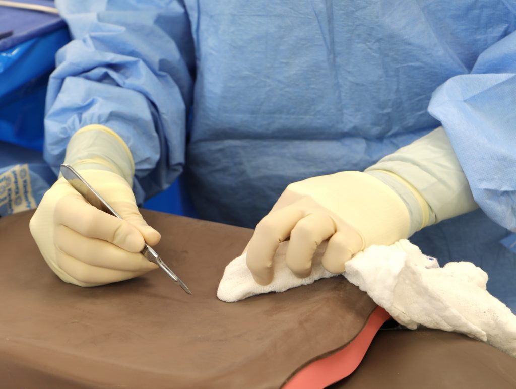 Student practicing scalpel on artificial human skin