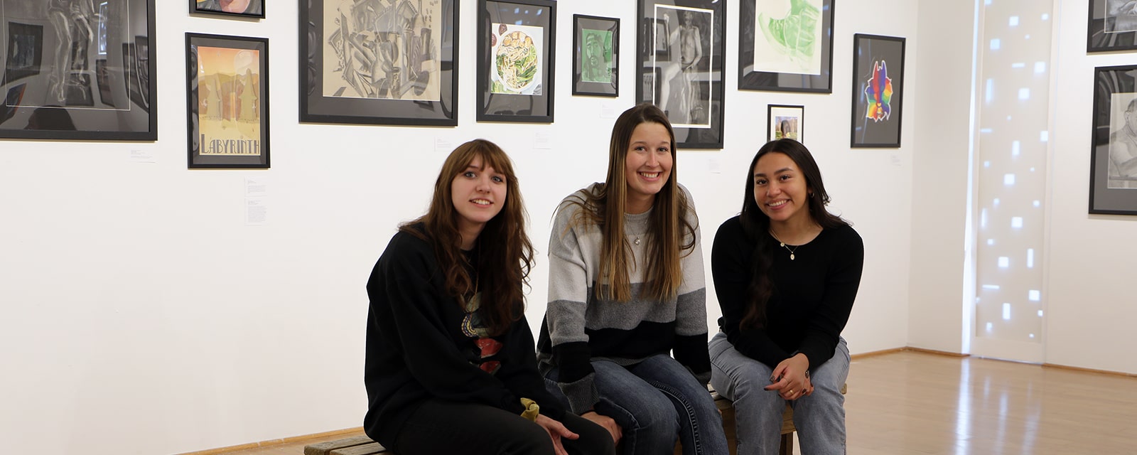Students posing for camera in art gallery