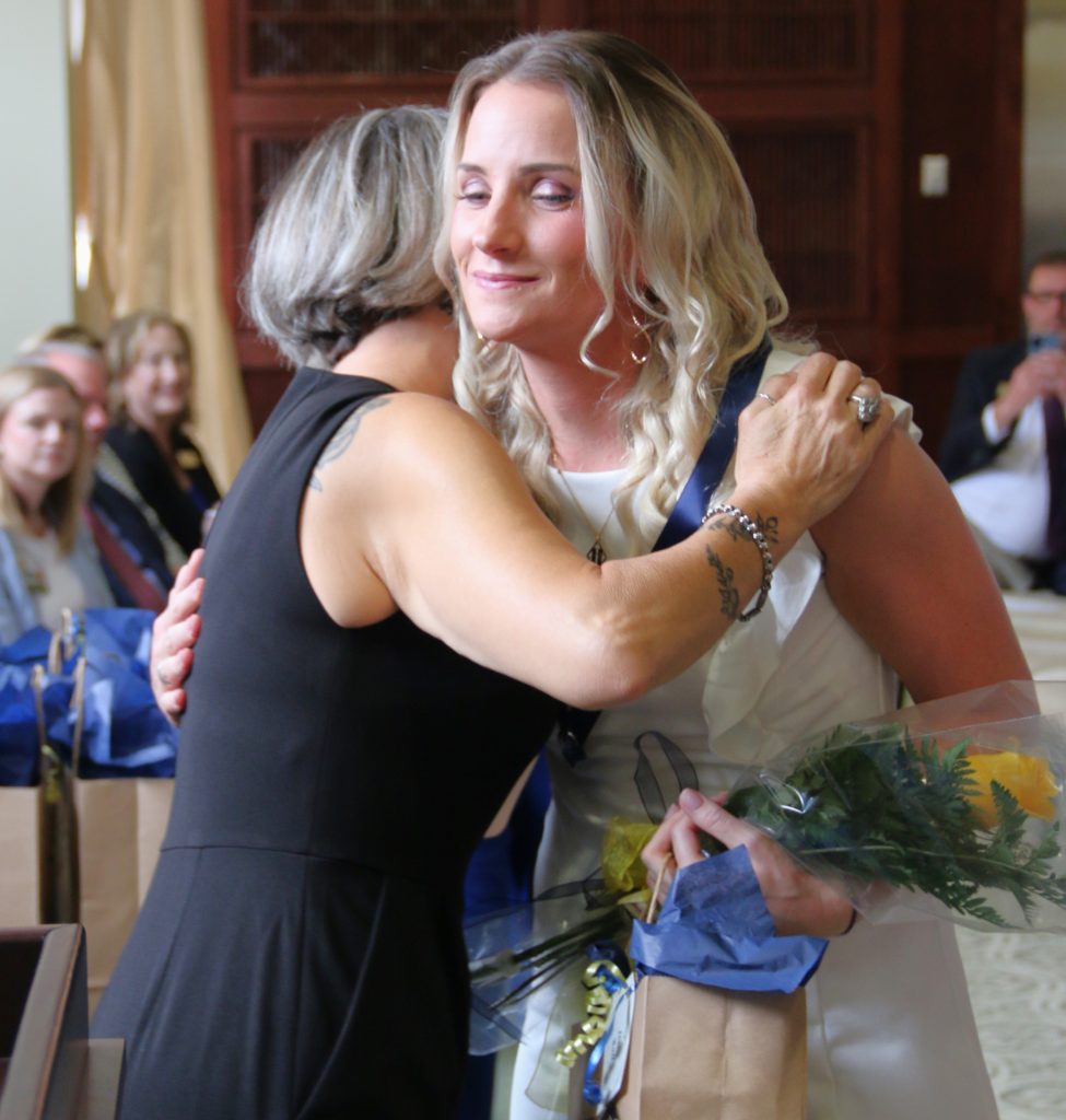 Student hugging teacher during pinning ceremony