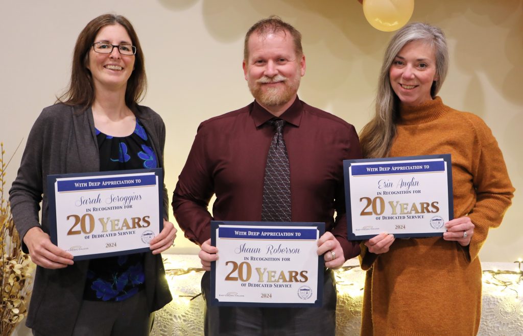 Three ECC employees holding certificates for 20 years of service,