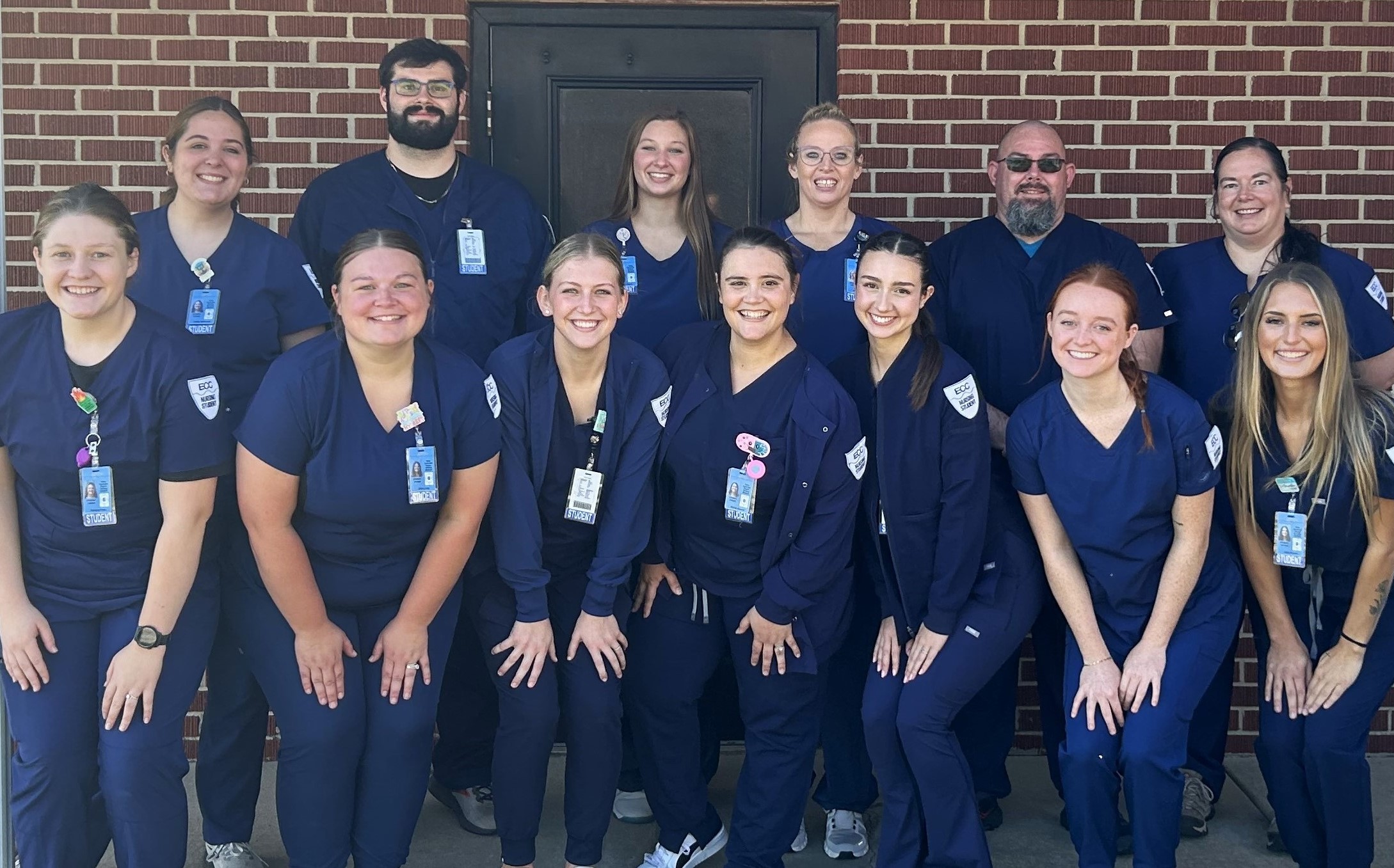 Rolla nursing students in blue scrubs standing in front of a brick wall on Clinical Orientation Day.