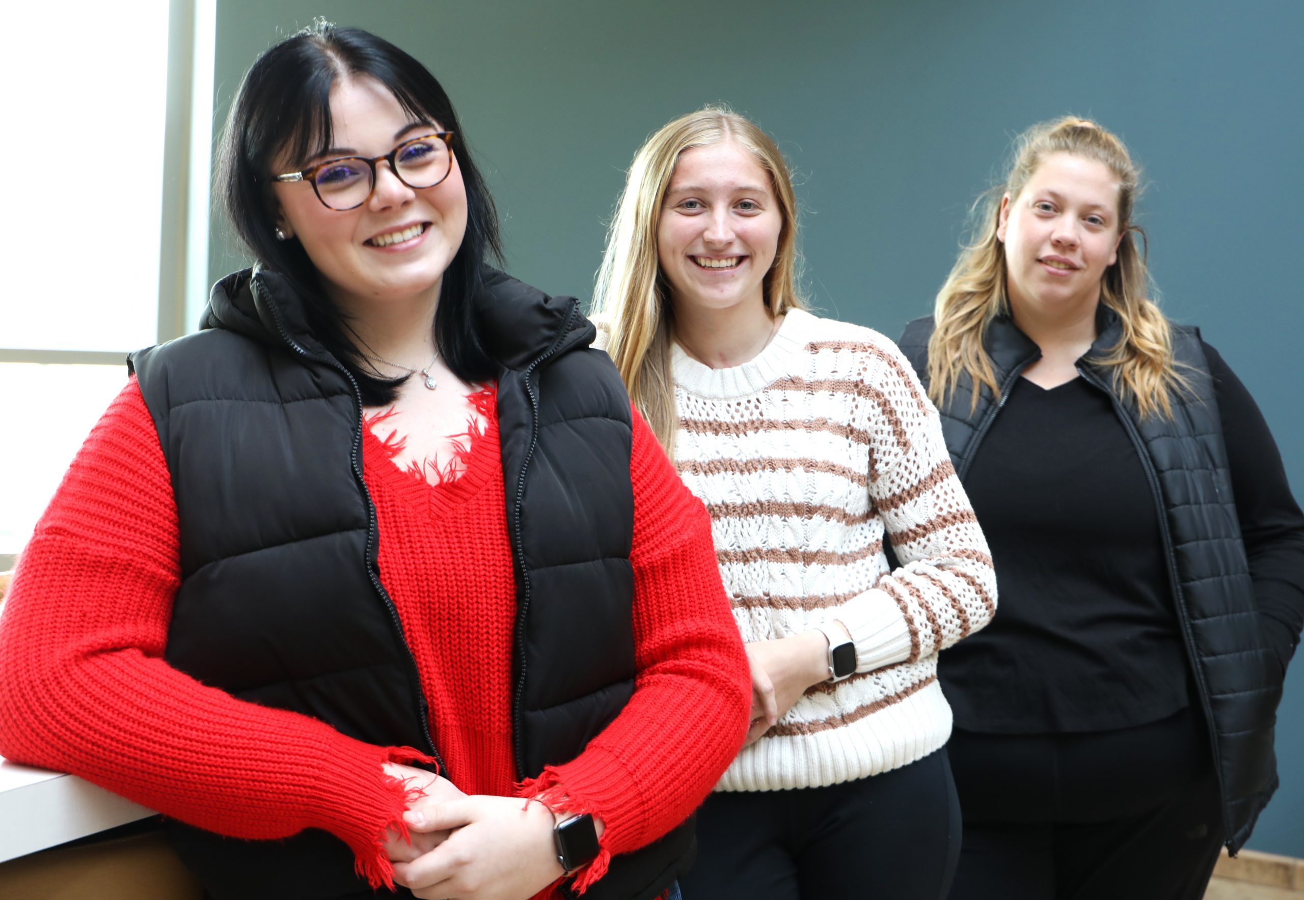 Three East Central College nursing students, Audrey Schroeder (left), Olivia Reed (center), and Toni Sells (right), standing together and smiling. Schroeder and Reed, both from Washington, and Sells, from Owensville, recently provided life-saving assistance to a man injured in a car accident near the college campus, showcasing their quick thinking and emergency response skills.